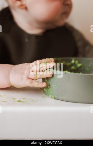 Primo piano del disordine delle mani del bambino durante lo svezzamento Foto Stock