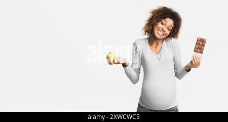 Gravidanza la dieta. Donna incinta scegliendo tra apple e il cioccolato Foto Stock