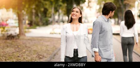 Ragazzo guardando altre donne a piedi con la ragazza a Park Foto Stock