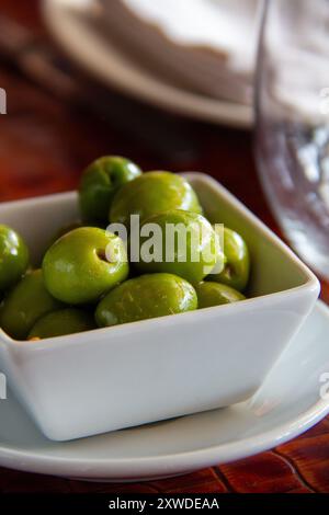 Primo piano di una piccola ciotola di olive verdi in un chiringuito andaluso a Marbella, Spagna Foto Stock