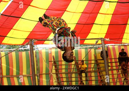 Sirajganj, Sirajganj, Bangladesh. 19 agosto 2024. Un membro di ''The New Lucky 7 Circus'' intrattiene il pubblico eseguendo le sue abilità sotto una tenda colorata a Sirajganj, Bangladesh. Il circo è una forma popolare di intrattenimento in Bangladesh che sta quasi scomparendo. Una tradizione di quasi cento anni, questo gioco è mostrato in un'enorme tenda colorata. Qui gli artisti mostrano le loro abilità attraverso acrobazie, acrobazie, clowning, burattini, camminate in fune. (Immagine di credito: © Syed Mahabubul Kader/ZUMA Press Wire) SOLO PER USO EDITORIALE! Non per USO commerciale! Foto Stock