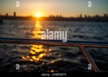 Uno splendido tramonto sul Bosforo di Istanbul, con il cielo che si illumina in calde tonalità di arancione e rosa, che proiettano una splendida luce sull'acqua e sulla città Foto Stock