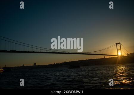 Le sfumature dorate del sole tramontare proiettano un caldo bagliore sul ponte e sulle acque tranquille, catturando l'eleganza della scena. Foto Stock