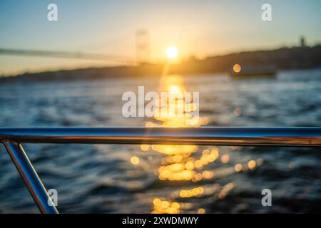 Le sfumature dorate del sole tramontare proiettano un caldo bagliore sul ponte e sulle acque tranquille, catturando l'eleganza della scena. Foto Stock