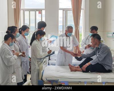 (240819) -- PECHINO, 19 agosto 2024 (Xinhua) -- questa foto non datata mostra li Bofan (3° R), decano onorario dell'ospedale di medicina tradizionale cinese della contea di Binchuan, che controlla le condizioni di un paziente ricoverato con i suoi apprendisti nella contea di Binchuan della Prefettura autonoma di Dalí Bai, nella provincia dello Yunnan della Cina sud-occidentale. Mentre la Cina celebra il suo settimo giorno dei medici, l'autorità sanitaria superiore del paese ha annunciato e onorato 10 modelli di personale medico quest'anno. I 10 medici sono personale esemplare che ha dato un contributo all'innovazione della scienza-tecnologia medica, allo sviluppo del mestiere Foto Stock