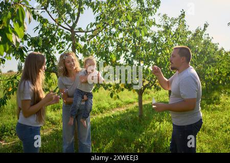 la famiglia di quattro persone sta giocando a bolle di cattura nel giardino Foto Stock