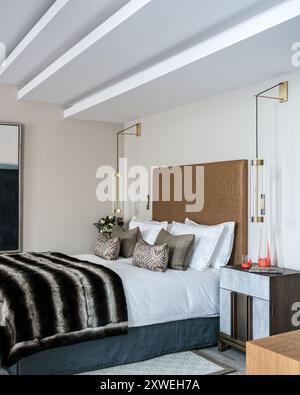 Pelliccia a righe su un letto matrimoniale in una lussuosa e moderna casa britannica. Londra, Regno Unito Foto Stock