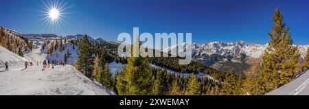Vista mozzafiato da un rifugio alpino su una catena montuosa e su un gruppo di sciatori in una giornata di sole Foto Stock