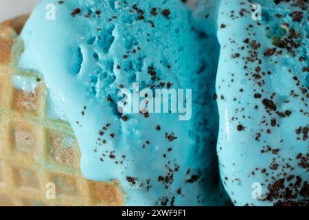 Vista ravvicinata di un gelato con biscotti blu in un cono di waffle. Foto Stock