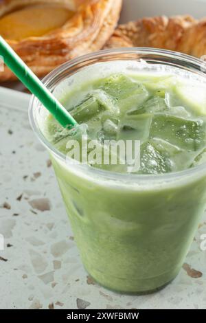 Vista ravvicinata di un latte matcha freddo in una tazza di plastica. Foto Stock