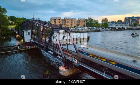 Trenino aereo sul ponte Steel Truss sul fiume con porticciolo Foto Stock