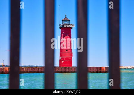 Faro di Red Kenosha incorniciato da Fence sul lago Michigan Foto Stock