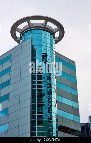 Moderna torre in vetro con finestre riflettenti e vista ad angolo basso Foto Stock