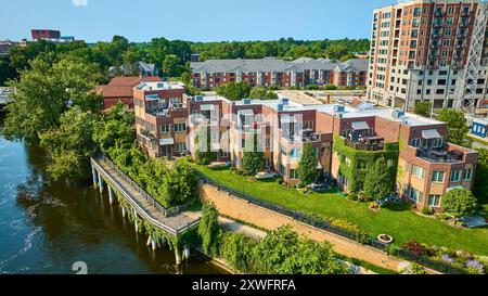 Volo aereo attraverso le moderne residenze sul lungofiume e la passeggiata sul lungofiume Foto Stock