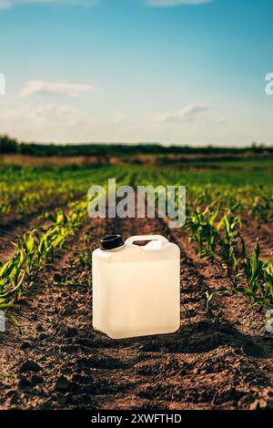 Tanica per erbicida nel campo del raccolto di mais, messa a fuoco selettiva Foto Stock