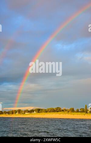 Rainbow Over Tranquil Beach al Sunset Eye Level Perspective Foto Stock