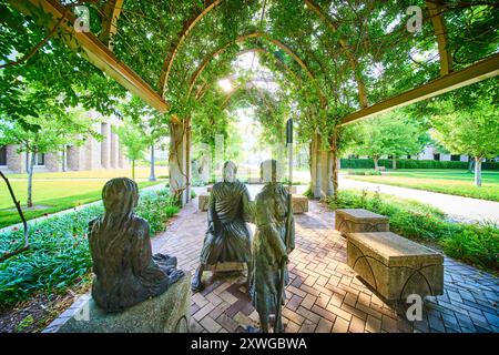 Statua dell'insegnamento di Gesù sotto Pergola nella prospettiva del livello degli occhi del giardino tranquillo Foto Stock