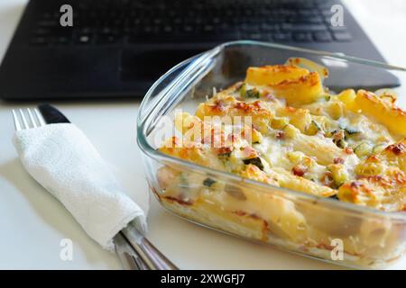 Pranzo con pasta in Tupperware presso il banco dell'ufficio Foto Stock