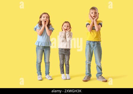 I bambini più piccoli hanno scioccato lo sfondo giallo Foto Stock