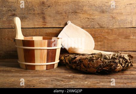 Secchio con mestolo e scopa di betulla per sauna su fondo in legno Foto Stock