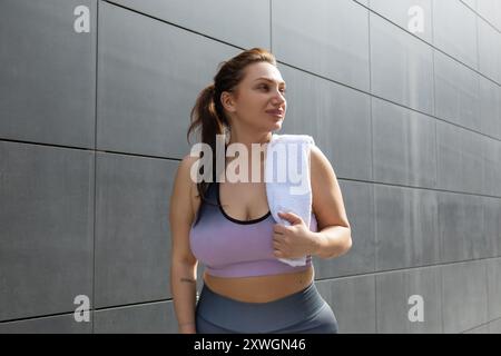 Giovane donna in sovrappeso in abbigliamento sportivo dopo l'allenamento Foto Stock