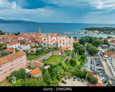 Vista aerea del porto principale della città di Krk sull'isola croata con le mura della città, il castello di Frankopan, i tetti rossi, la cattedrale, il monastero benedettino, Foto Stock