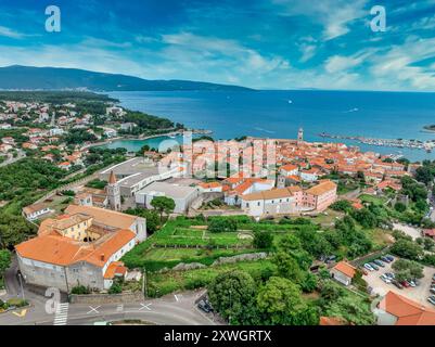 Vista aerea del porto principale della città di Krk sull'isola croata con le mura della città, il castello di Frankopan, i tetti rossi, la cattedrale, il monastero benedettino, Foto Stock