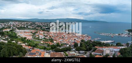 Vista aerea del porto principale della città di Krk sull'isola croata con le mura della città, il castello di Frankopan, i tetti rossi, la cattedrale, il monastero benedettino, Foto Stock