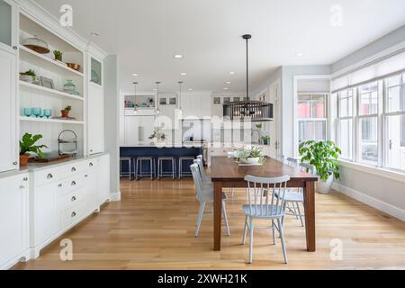 Zona pranzo con vista sulla cucina e molta luce naturale che arriva attraverso le pareti delle finestre Foto Stock