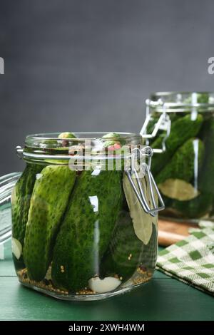 Fare sottaceti. Cetrioli freschi e spezie in vasetti su tavola di legno Foto Stock