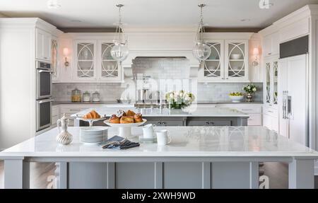 Cucina bianca di alto livello con due isole e fiori nel lavandino Foto Stock