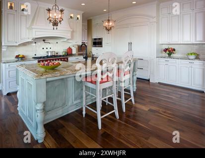 Cucina di campagna francese bianca con accenti colorati, piano cottura rosso e doppio frigorifero Foto Stock