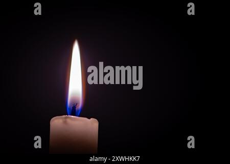 Una candela brucia al buio Foto Stock