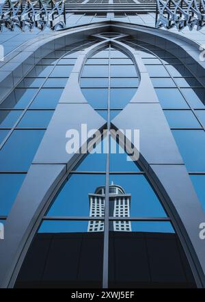 Edificio dall'architettura moderna, sfondo astratto nel centro cittadino di Dubai, Emirati Arabi Uniti. Facciata in vetro, frammento della facciata di un edificio in vetro. Esterno di un moderno arco Foto Stock