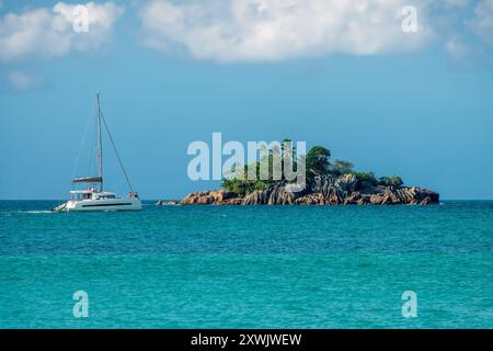 Turisti a bordo di una barca a vela sull'isola di St Pierre, isoletta rocciosa panoramica nell'isola di Praslin, Seychelles Foto Stock