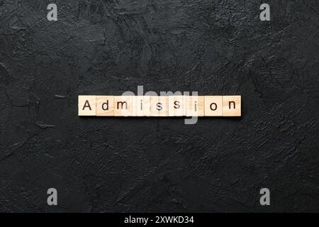 Parola DI AMMISSIONE scritta su blocco di legno. Testo DI AMMISSIONE su tabella di cemento per il vostro desing, concetto. Foto Stock