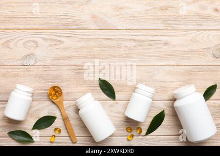 Le capsule di Omega-3 si trovano in un flacone bianco su un tavolo con il fondo verde delle foglie. Compresse di olio di pesce. Additivi biologicamente attivi omega 6, omega 9, vitam Foto Stock