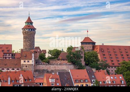 Nürnberger Stadtbild am Abend Das foto zeigt die Kaiserburg in Nürnberg, Bayern, Deutschland, kurz vor dem Sonnenuntergang während des gleichzeitigen Mondaufgangs. Die Aufnahme fängt das warme, goldene Licht ein, das die Ziegeldächer der Altstadt und die mittelalterlichen Türme der Burg in ein sanftes, leuchtendes Licht taucht. Nürnberg Bayern Deutschland *** paesaggio urbano di Norimberga la sera la foto mostra il Castello Imperiale di Norimberga, Baviera, Germania, poco prima del tramonto durante il sorgere simultaneo della luna, lo scatto cattura la calda e dorata luce che bagna i tetti piastrellati del vecchio Foto Stock