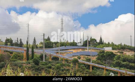 File di pannelli solari sono in fase di installazione su una collina, fornendo energia pulita all'area circostante Foto Stock