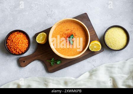 Tradizionale zuppa turca di lenticchie rosse con ingredienti in ciotola su tavola rustica Foto Stock