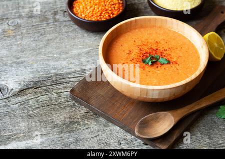 Tradizionale zuppa turca di lenticchie rosse con ingredienti in ciotola su tavola rustica Foto Stock