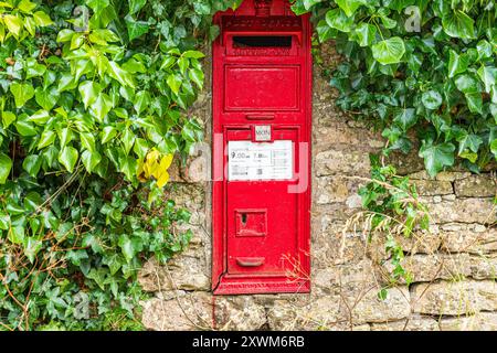 La cassetta delle lettere vittoriana VR entra in un muro di pietra a secco nel villaggio Cotswold di Middle Duntisbourne, Gloucestershire, Inghilterra Regno Unito Foto Stock