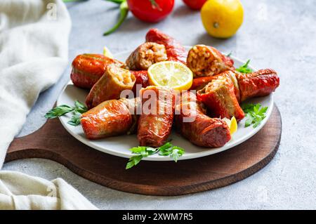 Peperoni secchi ripieni cotti in pentola in piatto su fondo rustico Foto Stock
