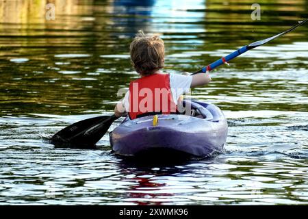 Vista posteriore di un ragazzo in kayak Foto Stock