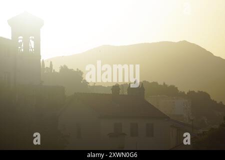 Mattina nel centro di Herceg Novi: Chiese e case della città vecchia illuminate dai raggi del sole nascente. Vista dalla fortezza di forte Mare Foto Stock