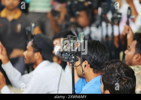 I bengalesi coprono gli incidenti utilizzando dispositivi mobili per le strade di Dacca, Bangladesh, il 20 agosto 2024. Il giornalismo mobile è sempre più diffuso Foto Stock