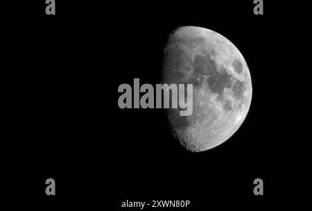 Mezzaluna cerata Half Moon. Dettagli della superficie lunare con spazio di copia. Satellite naturale della Terra nel cielo notturno. Concetto di astronomia Foto Stock