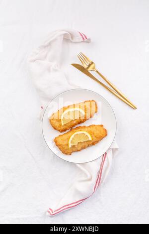 Pesce impanato croccante con salsa e limone Foto Stock
