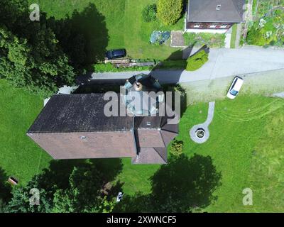 Una vista aerea di Kuratienkirche Meschach circondata da lussureggiante vegetazione. Gotzis, Austria Foto Stock