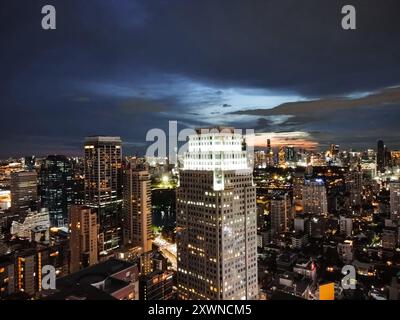 Vista aerea di Bangkok dopo il tramonto con le luci della città e lo skyline in una giornata nuvolosa, vista da Asok, Sukhumvit Foto Stock